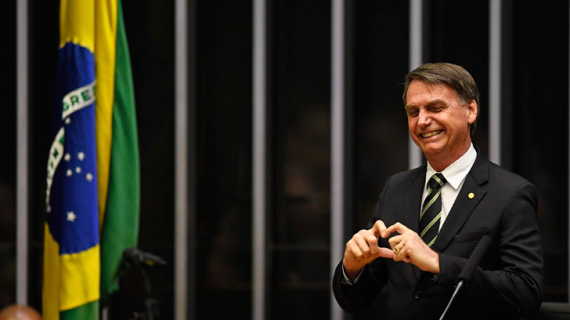 President-elect Jair Bolsonaro waves inside the Congress in Brasilia ahead of a ceremony celebrating the 30th anniversary of the Brazilian Constitution.