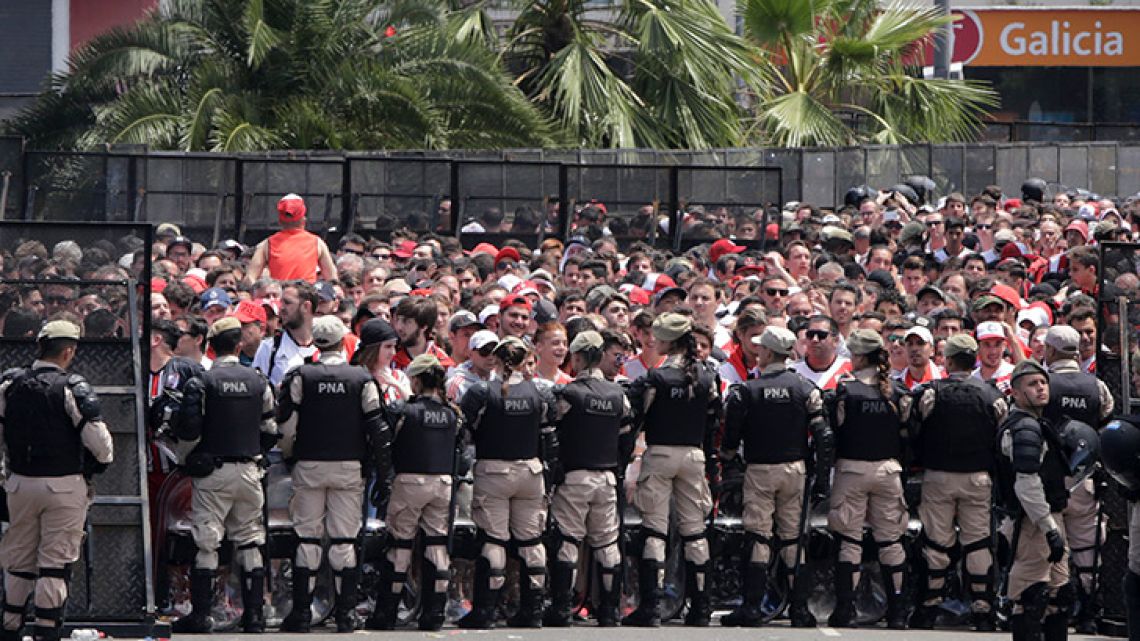 Security forces stand guard outside outside the Monumental, where River Plate fans gather before the announcement that their team's final Copa Libertadores match against rival Boca Juniors was to be suspended for a second day in a row.