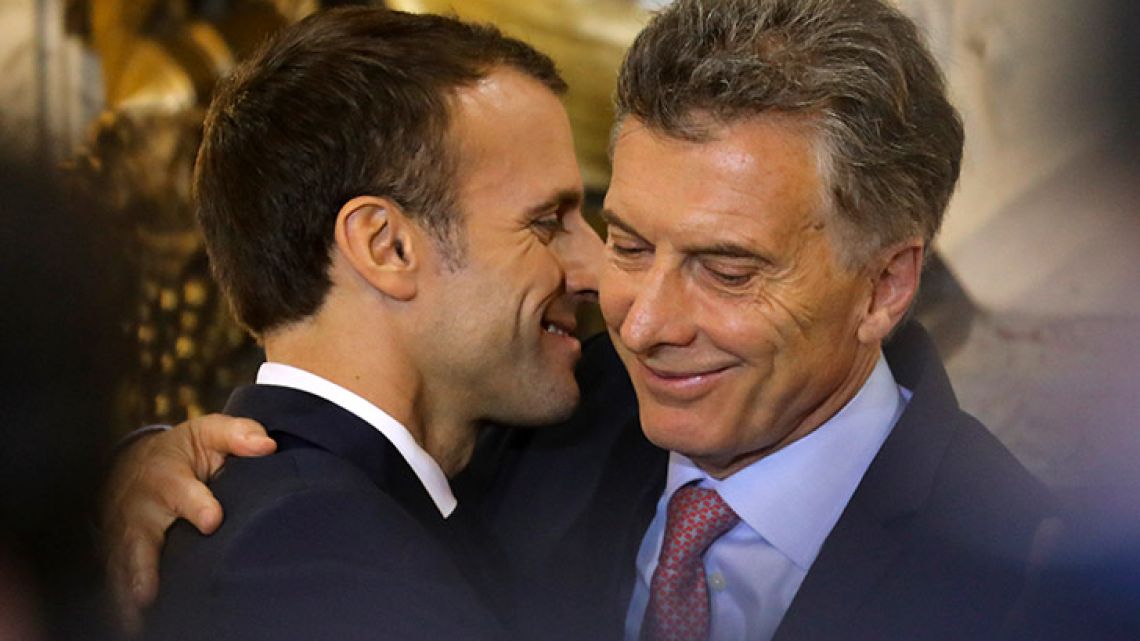 France's President Emmanuel Macron (left) hugs Mauricio Macri during a press conference at the Casa Rosada this morning.