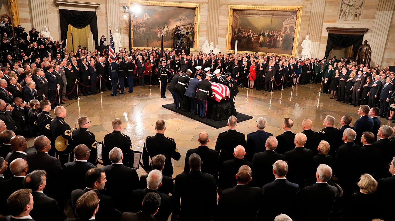  El ataúd del ex presidente de los Estados Unidos, George H.W. Bush es entregado por una guardia de honor militar que se encuentra en el estado de la Rotonda del Capitolio de los EE. UU. Mientras miembros de la Cámara de Representantes de la Cámara de los EE. UU. Observan en Washington, DC.