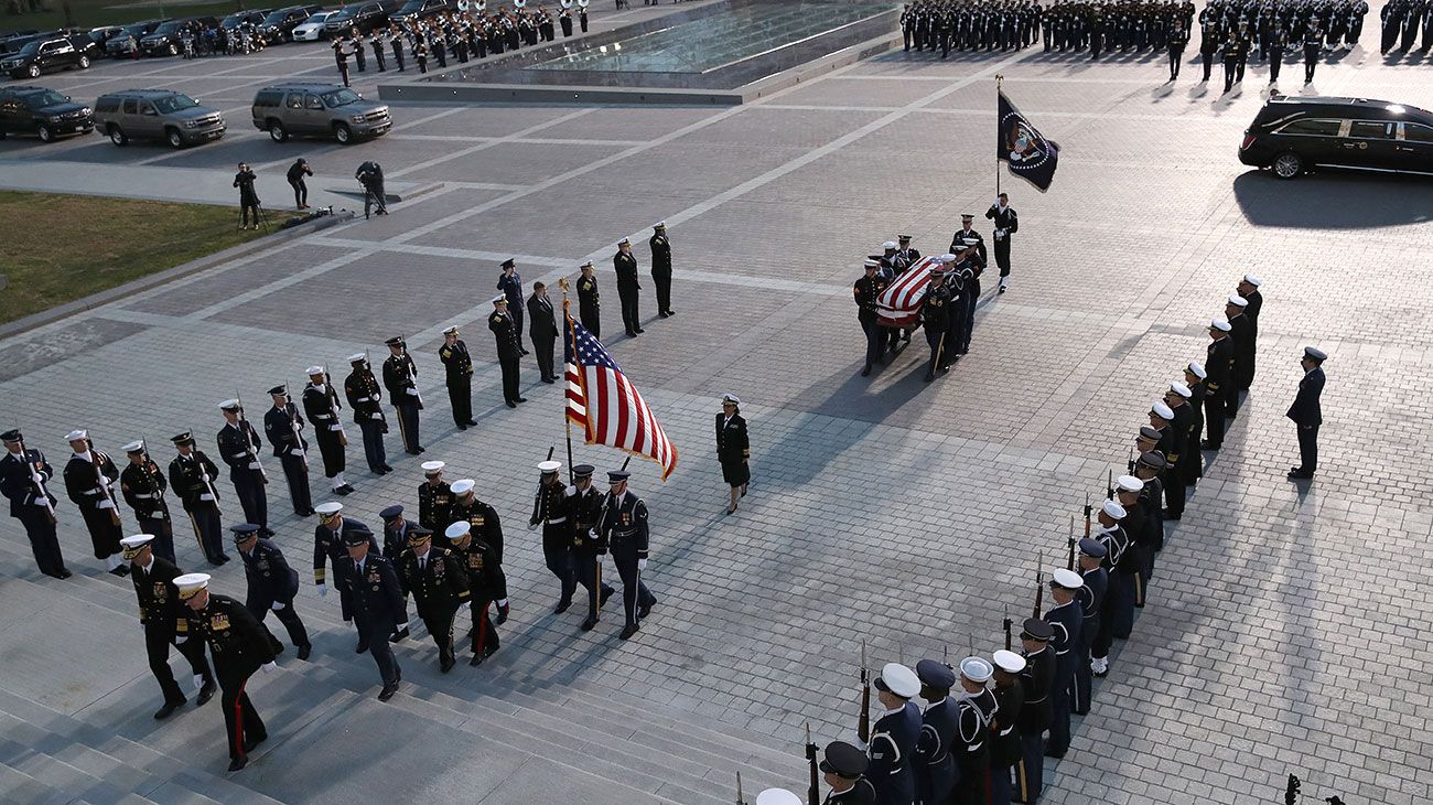  El ataúd del ex presidente de los Estados Unidos, George H.W. Bush es entregado por una guardia de honor militar que se encuentra en el estado de la Rotonda del Capitolio de los EE. UU. Mientras miembros de la Cámara de Representantes de la Cámara de los EE. UU. Observan en Washington, DC.