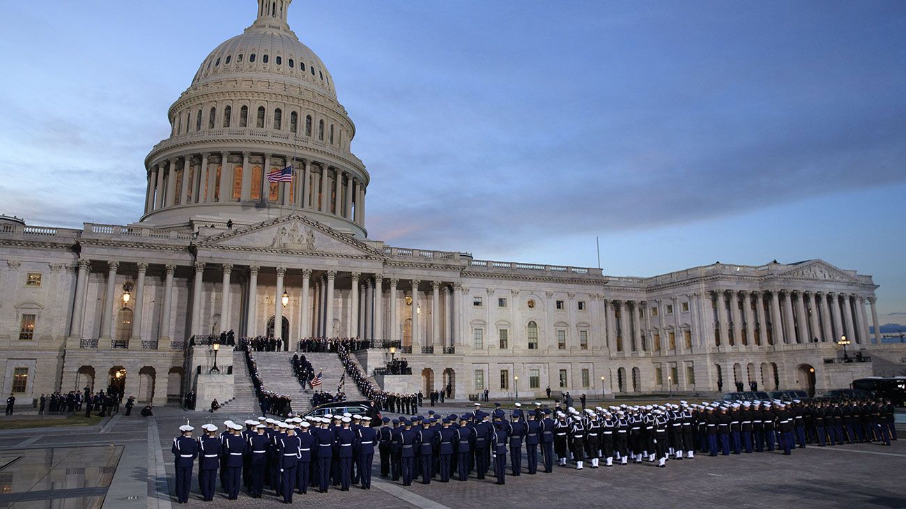  El ataúd del ex presidente de los Estados Unidos, George H.W. Bush es entregado por una guardia de honor militar que se encuentra en el estado de la Rotonda del Capitolio de los EE. UU. Mientras miembros de la Cámara de Representantes de la Cámara de los EE. UU. Observan en Washington, DC.