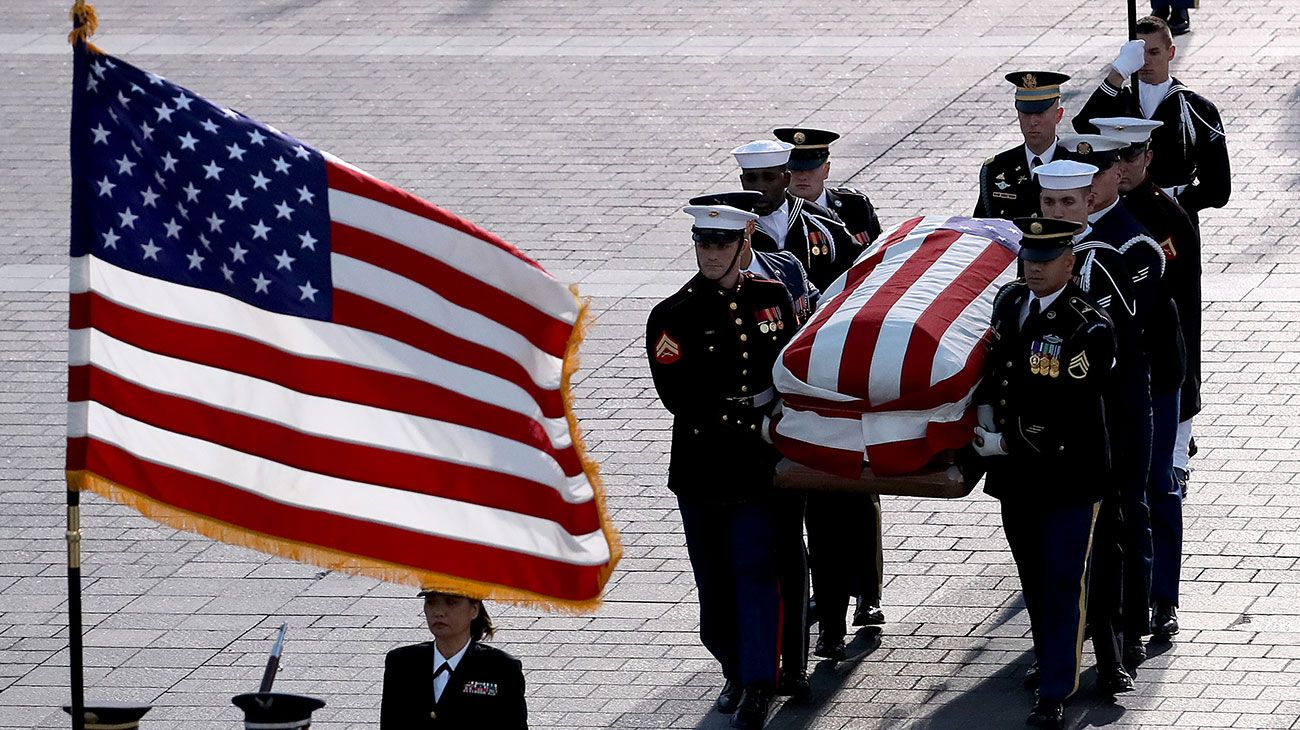  El ataúd del ex presidente de los Estados Unidos, George H.W. Bush es entregado por una guardia de honor militar que se encuentra en el estado de la Rotonda del Capitolio de los EE. UU. Mientras miembros de la Cámara de Representantes de la Cámara de los EE. UU. Observan en Washington, DC.