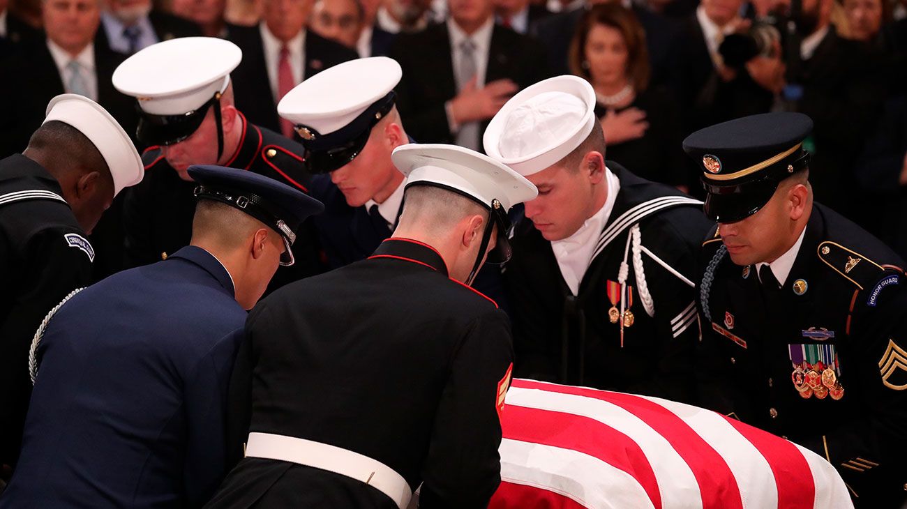  El ataúd del ex presidente de los Estados Unidos, George H.W. Bush es entregado por una guardia de honor militar que se encuentra en el estado de la Rotonda del Capitolio de los EE. UU. Mientras miembros de la Cámara de Representantes de la Cámara de los EE. UU. Observan en Washington, DC.