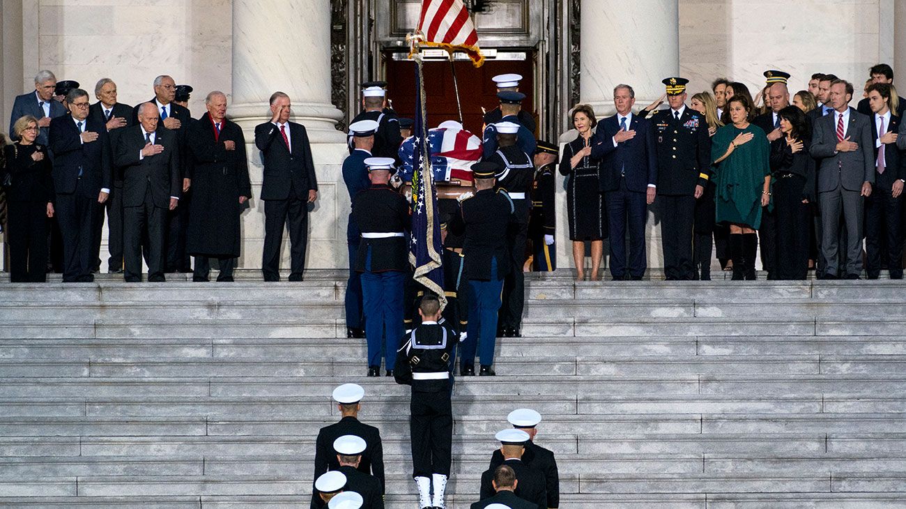  El ataúd del ex presidente de los Estados Unidos, George H.W. Bush es entregado por una guardia de honor militar que se encuentra en el estado de la Rotonda del Capitolio de los EE. UU. Mientras miembros de la Cámara de Representantes de la Cámara de los EE. UU. Observan en Washington, DC.