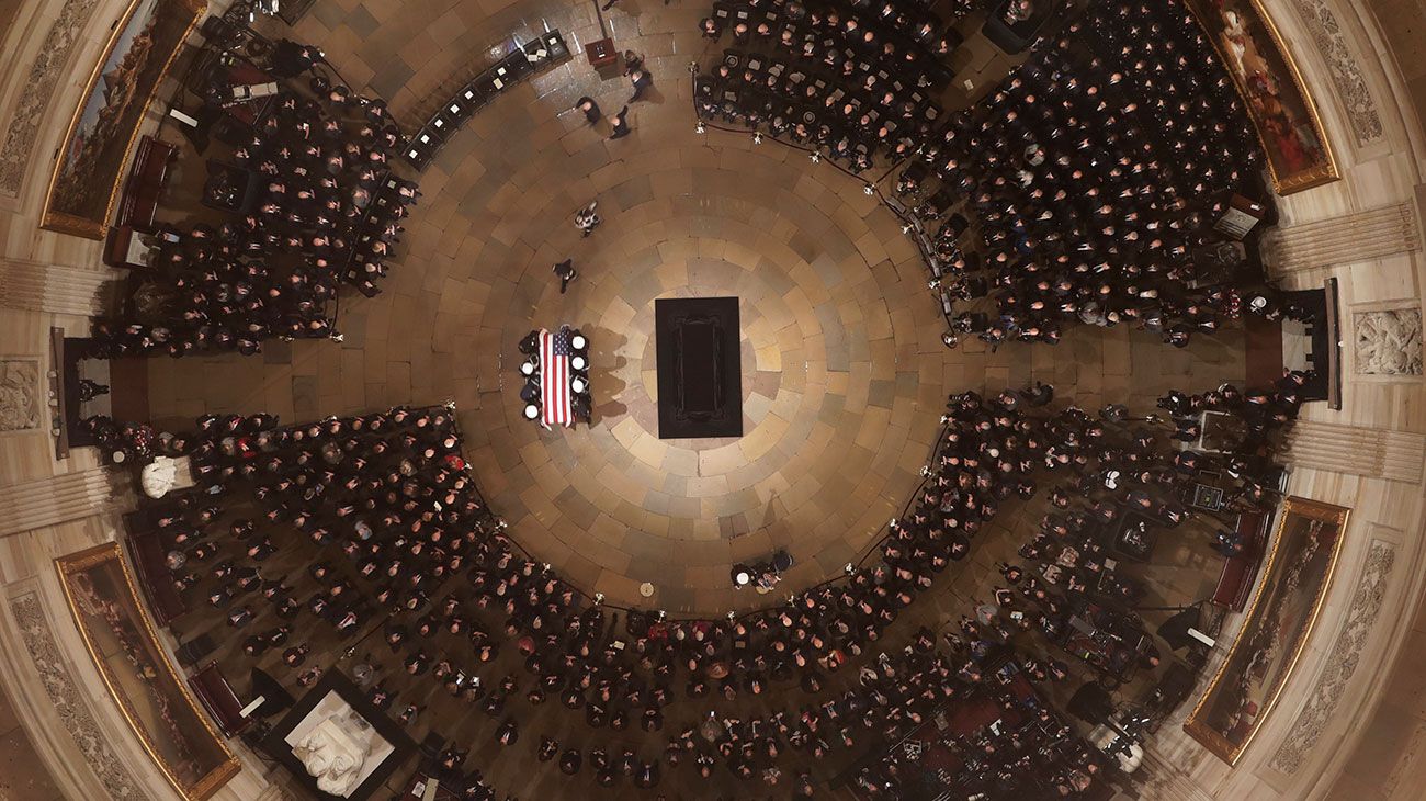  El ataúd del ex presidente de los Estados Unidos, George H.W. Bush es entregado por una guardia de honor militar que se encuentra en el estado de la Rotonda del Capitolio de los EE. UU. Mientras miembros de la Cámara de Representantes de la Cámara de los EE. UU. Observan en Washington, DC.