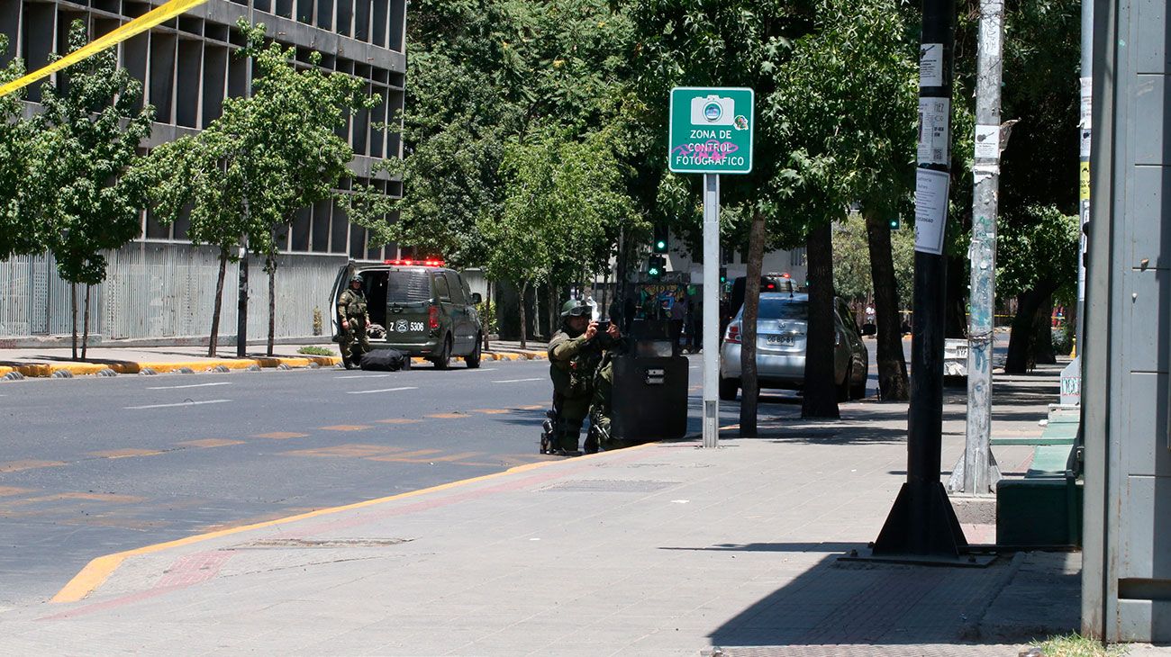 Miembros del Grupo de Operaciones Especiales de la Policía Chilena buscan cerca de una parada de autobús donde varias personas resultaron heridas luego de la explosión, en Santiago, Chile.