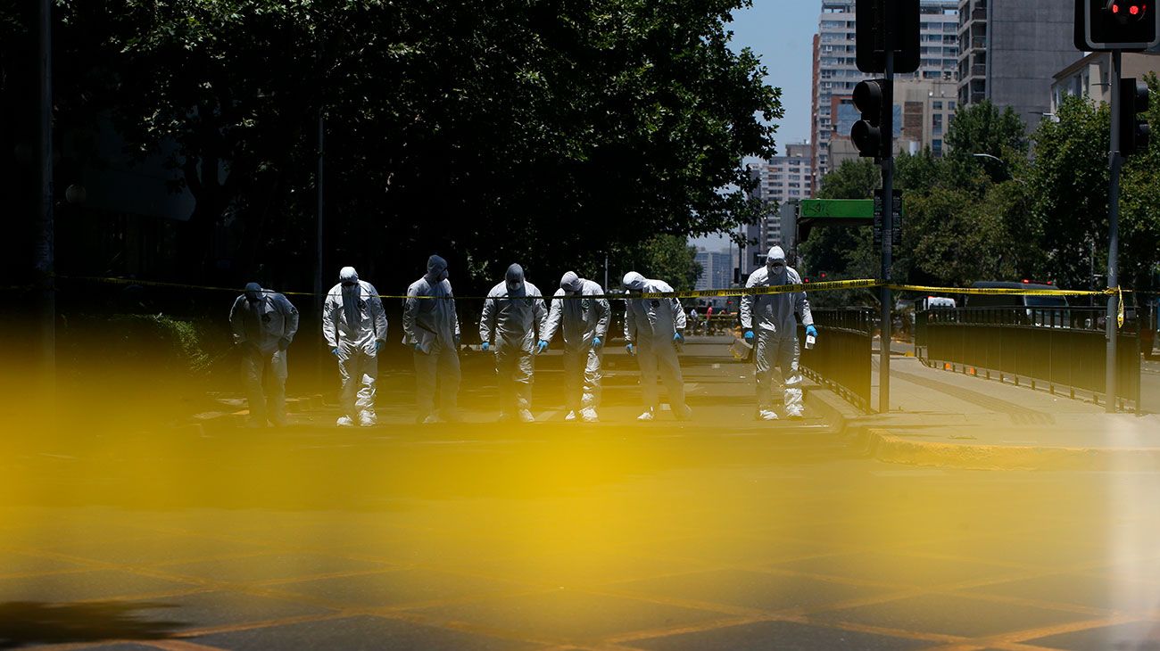 Miembros del Grupo de Operaciones Especiales de la Policía Chilena buscan cerca de una parada de autobús donde varias personas resultaron heridas luego de la explosión, en Santiago, Chile.