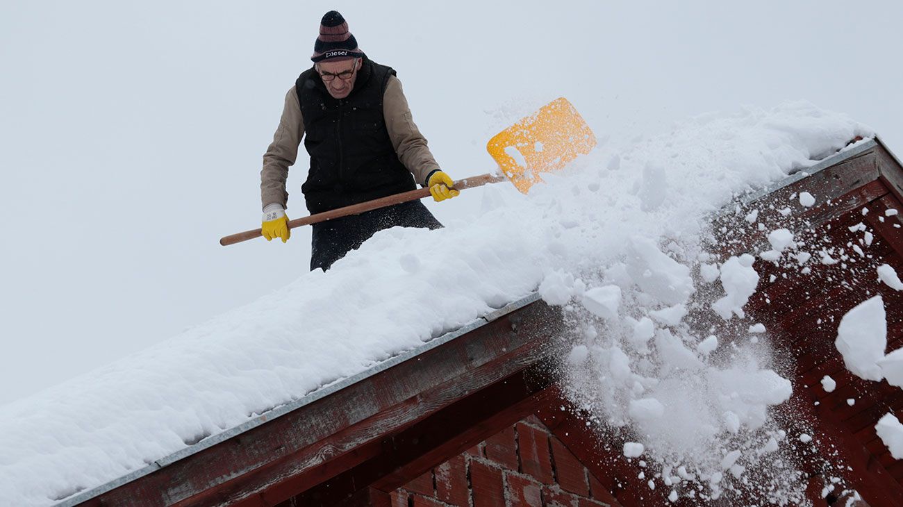 Un hombre quita la nieve del techo de su casa en una aldea remota cerca de Kladanj, a 80 km al norte de Sarajevo, Bosnia