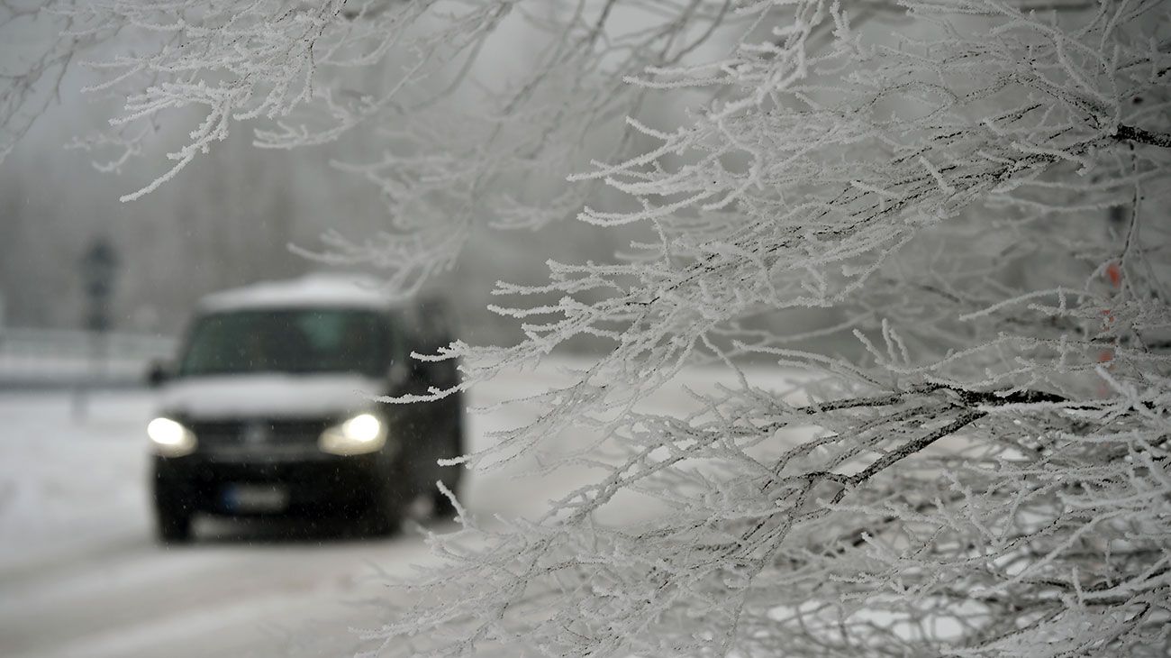 Un automóvil maneja sobre una calle cubierta de nieve en Dietges, Alemania.