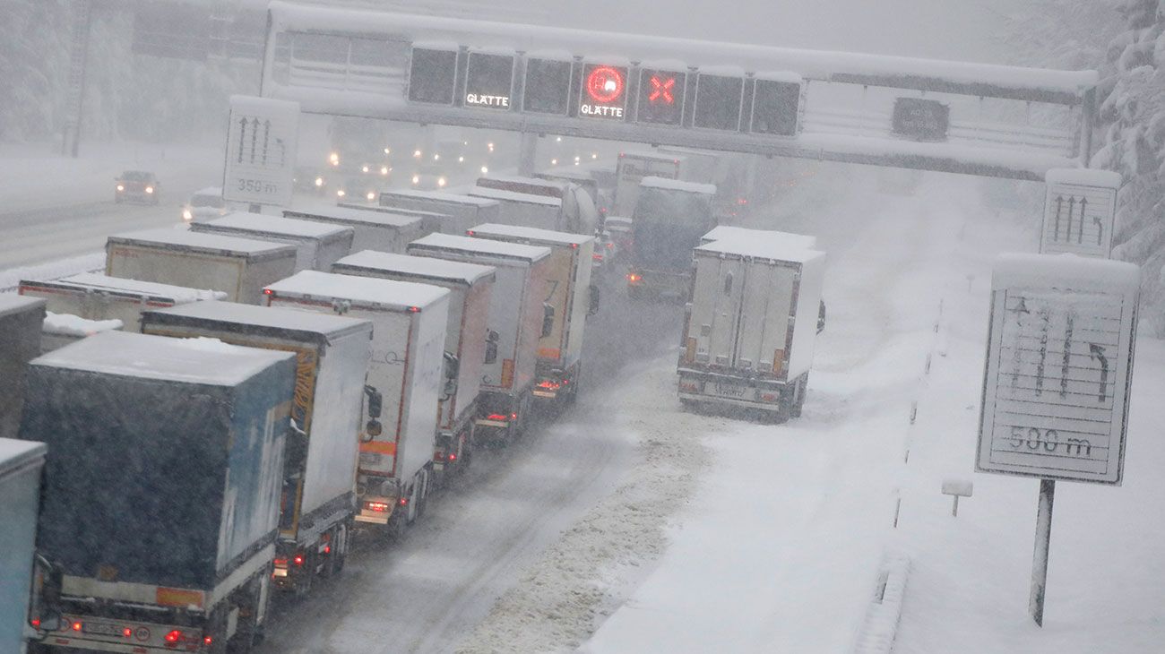 Los camiones hacen cola durante la caída de nieve en la autopista A 8 en Sauerlach cerca de Munich, Alemania.