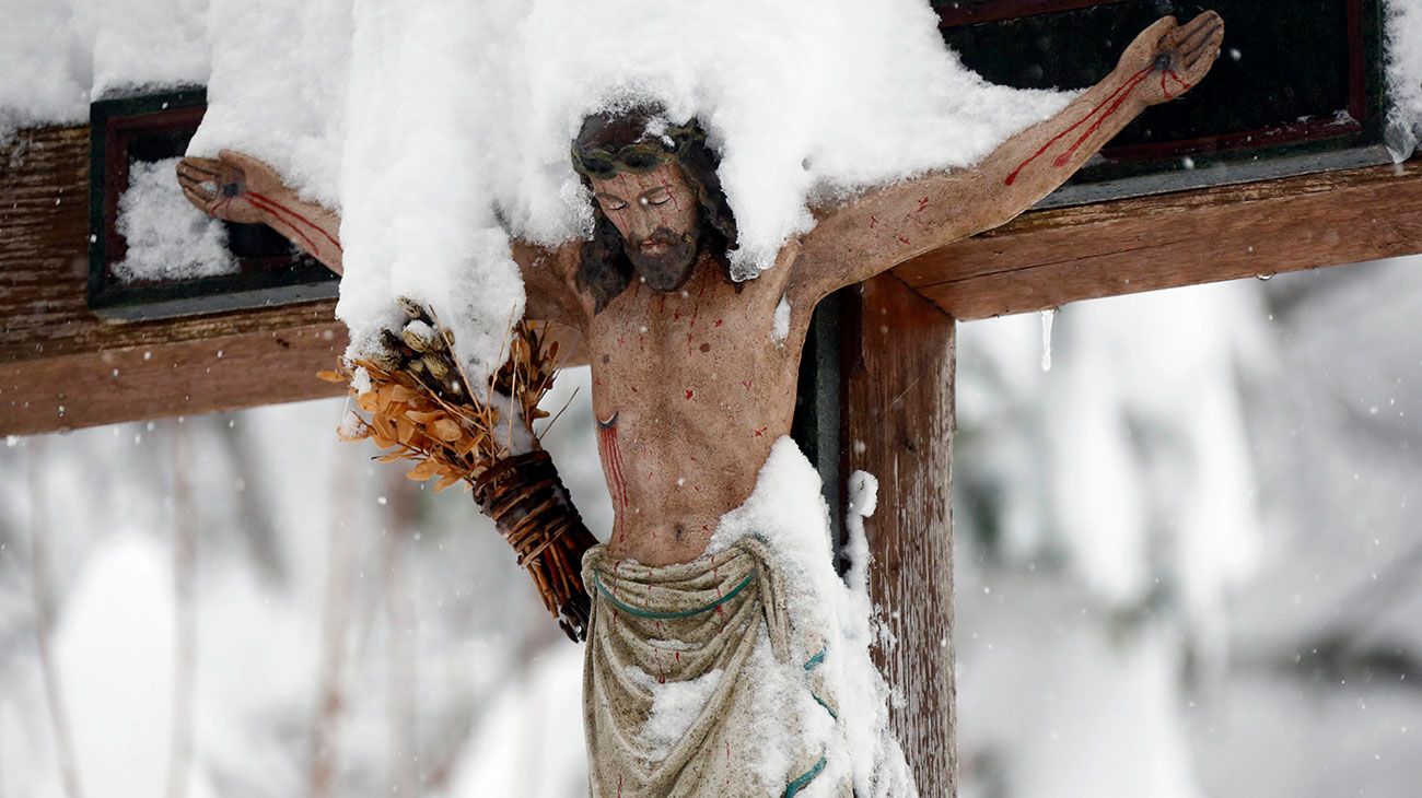 Un crucifijo cubierto de nieve se encuentra en Warngau, al sur de Munich, Alemania