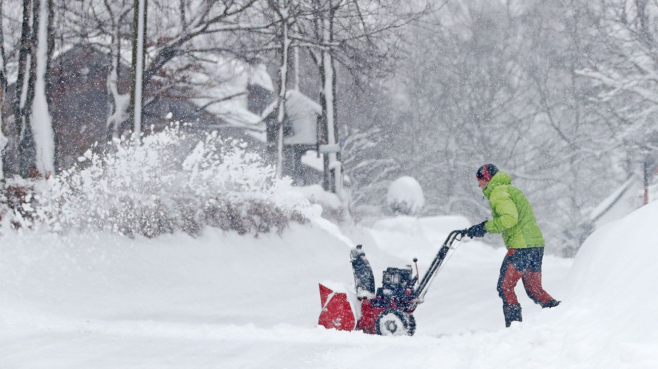 Un hombre usa un soplador de nieve después de que caiga una gran nevada cerca de Irschenberg, al sur de Munich, Alemania.