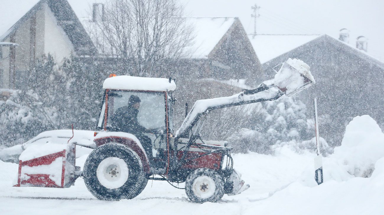Un hombre usa una excavadora después de nevadas fuertes cerca de Irschenberg en el sur de Munich, Alemania.