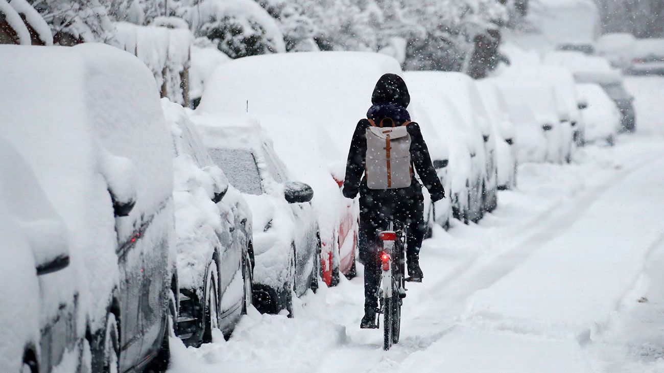 Una mujer se abre camino en una bicicleta a primera hora de la mañana después de que caiga una gran nevada en Munich, Alemania.