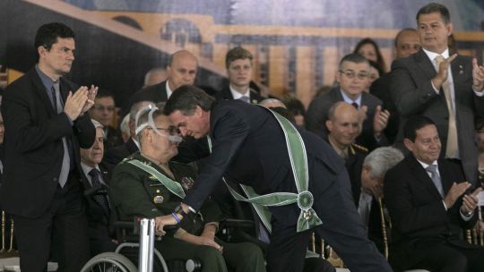 Acto. Bolsonaro abraza a Eduardo Villas Bôas, ante la atenta mirada del ministro Sérgio Moro.