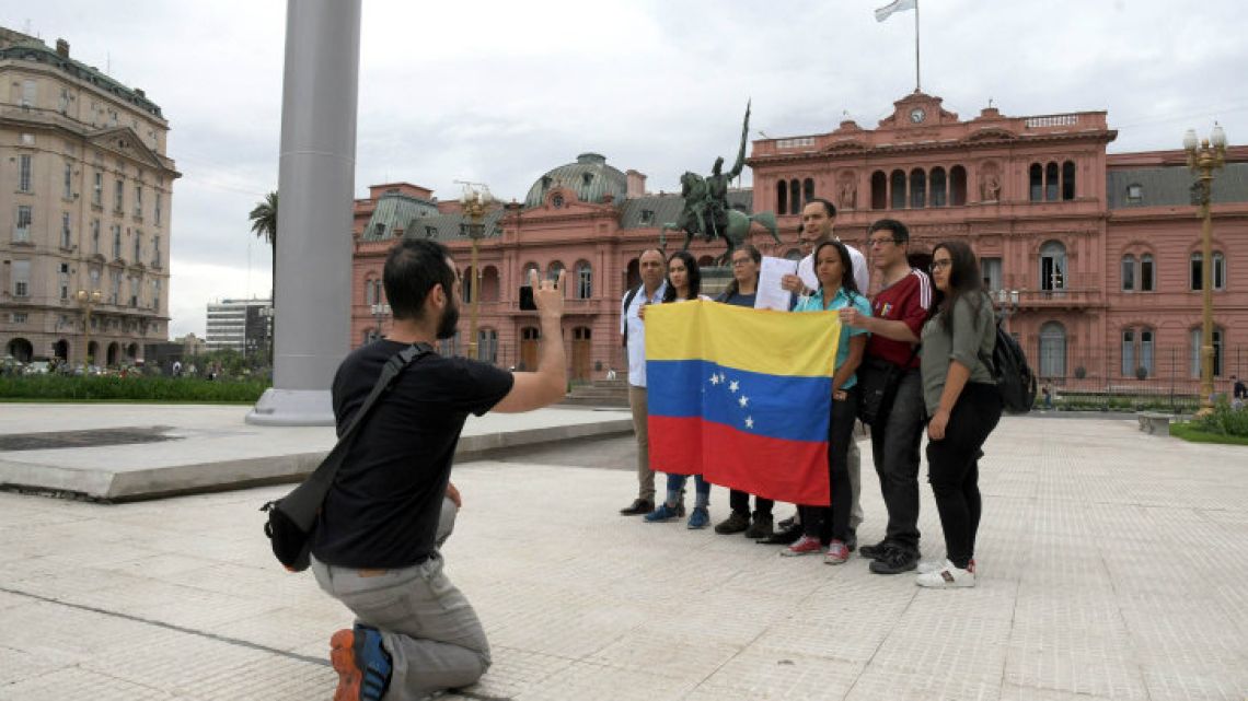 Venezuelans who now live in Argentina pose with a flag of their country outside the Casa Rosada.