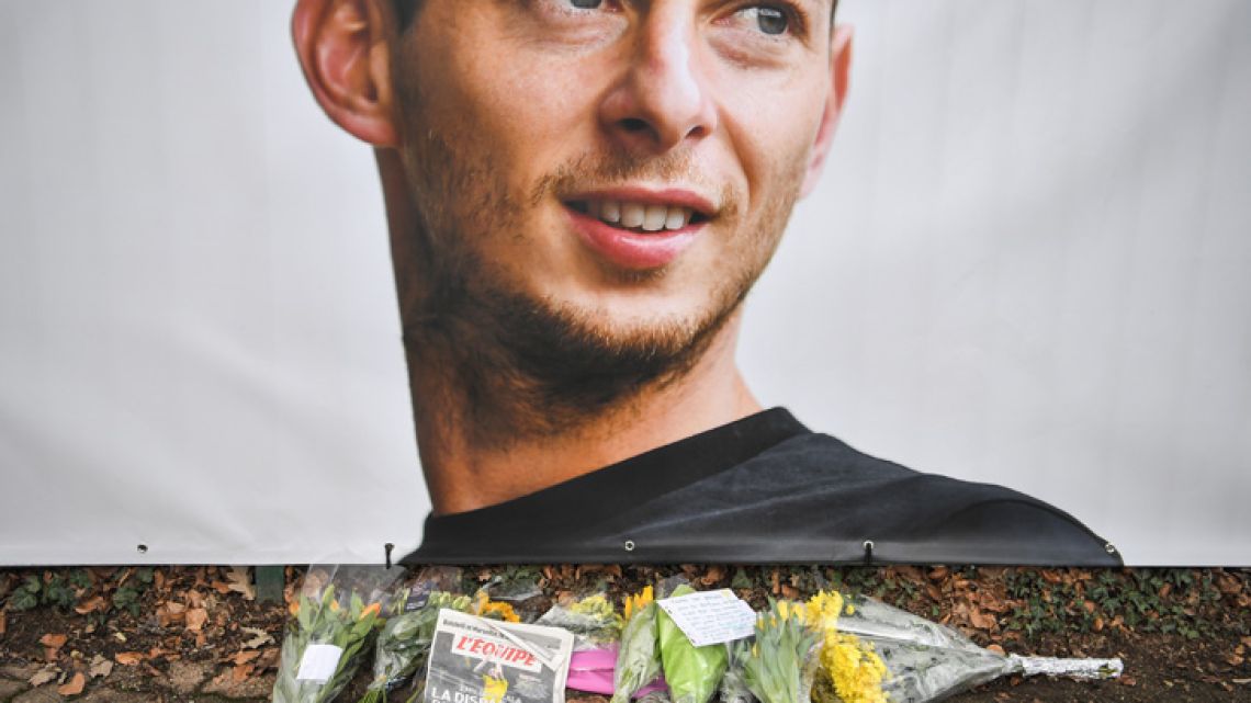 Flowers and candles are left at an informal tribute to missing footballer Emiliano Sala, in front of the entrance of the FC Nantes football club training centre in La Chapelle-sur-Erdre.