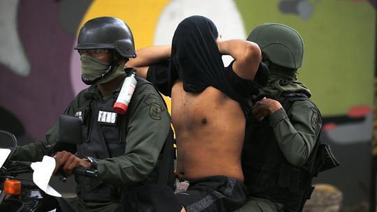 moto. Un manifestante detenido durante las protestas opositoras.