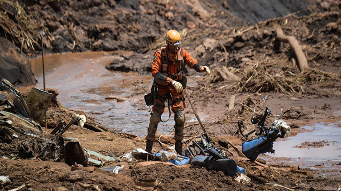 A rescuer removes debris as he works in the search for victims, four days after the collapse of a dam at an iron-ore mine belonging to Brazil's giant mining company Vale near the town of Brumadinho, state of Minas Gerais, southeastern Brazil, on January 28, 2019. The search for survivors intensified on Monday, on its fourth day, with the support of an Israeli contingent, after communities were devastated by a dam collapse that killed at least 60 people at a Brazilian mining complex -- with hopes fading for 292 still missing. A barrier at the site burst on Friday, spewing millions of tons of treacherous sludge and engulfing buildings, vehicles and roads.  
