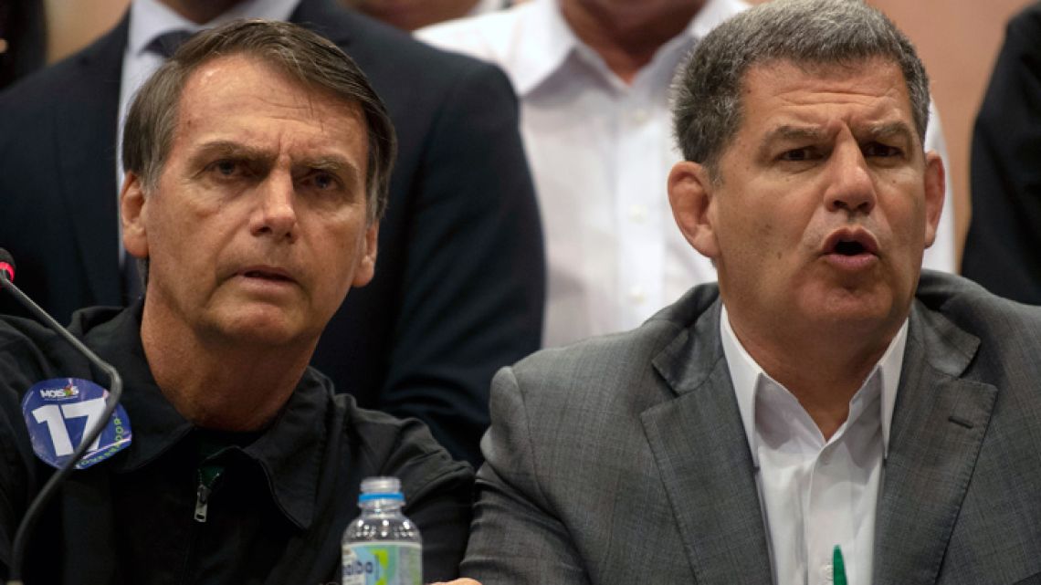 In this file picture taken on October 11, 2018 the presidential candidate of Brazil's right-wing Social Liberal Party (PSL), Jair Bolsonaro (L), and the president of the PSL, Gustavo Bebianno, offer a press conference in Rio de Janeiro, Brazil. Brazilian President Jair Bolsonaro on February 18, 2019 sacked a close aide who helped get him elected, Gustavo Bebianno, after a storm within their ruling PSL party over suspected improper campaign financing. Bolsonaro "has decided to dismiss as of today Gustavo Bebianno as minister of the general secretariat of the presidency," spokesman Otavio do Rego Barros told a news conference in Brasilia. The spokesman did not explain the firing, saying it was a "personal decision" by Bolsonaro.