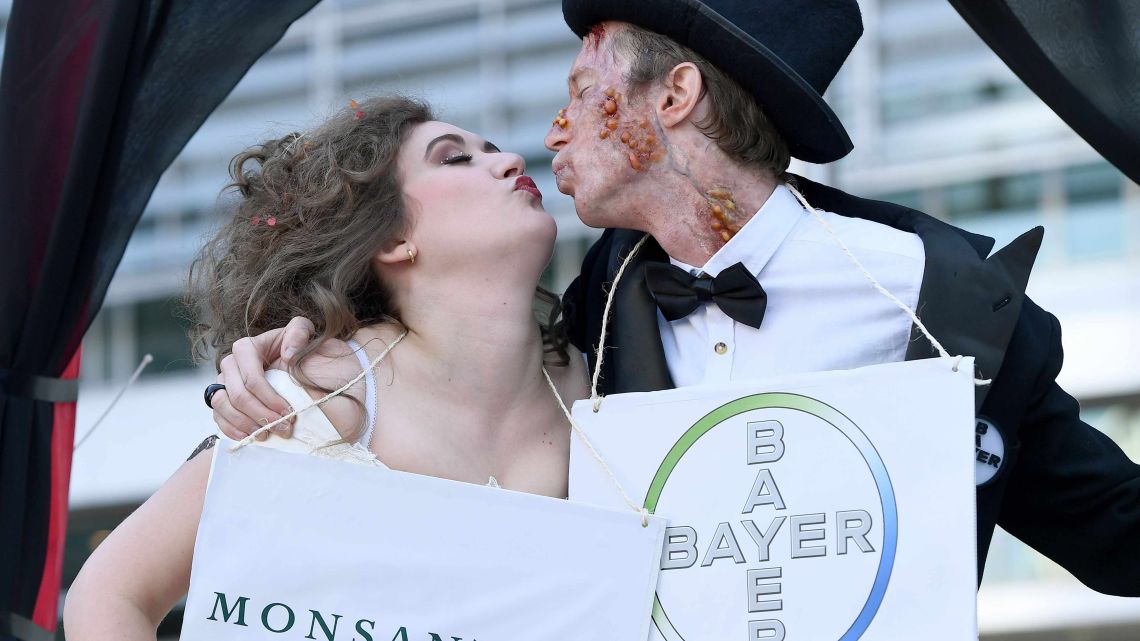 Activists stage a mock "Marriage made in Hell" in 2017 to protest against the merger between US agrochemical giant Monsanto and German Chemical multinational Bayer in front of the European Commission in Brussels.