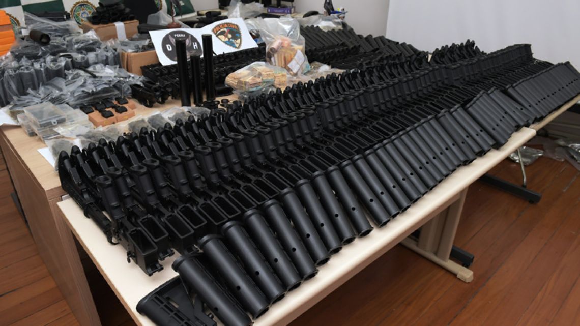 Automatic weapons, money and other equipments seized at the house of a friend of Brazilian military police sergeant Ronnie Lessa -arrested in relation to the killing of Rio de Janeiro's councilwoman and activist Marielle Franco-, are displayed at the Civil Police headquarters in Rio de Janeiro, Brazil on March 12, 2019. Two police officers were arrested Tuesday in the killing of Rio city councilor and black gay rights activist Marielle Franco, prosecutors said, almost a year to the day after the brazen murder shocked Brazil. 