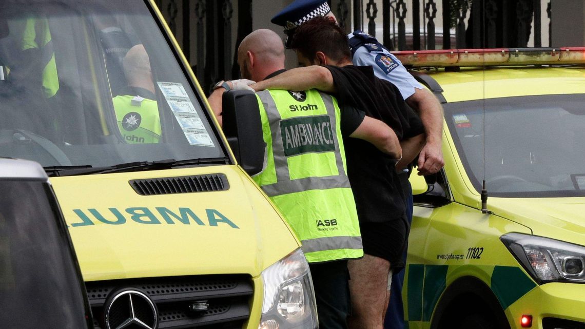 Police and ambulance staff help a wounded man from outside a mosque in central Christchurch, New Zealand.