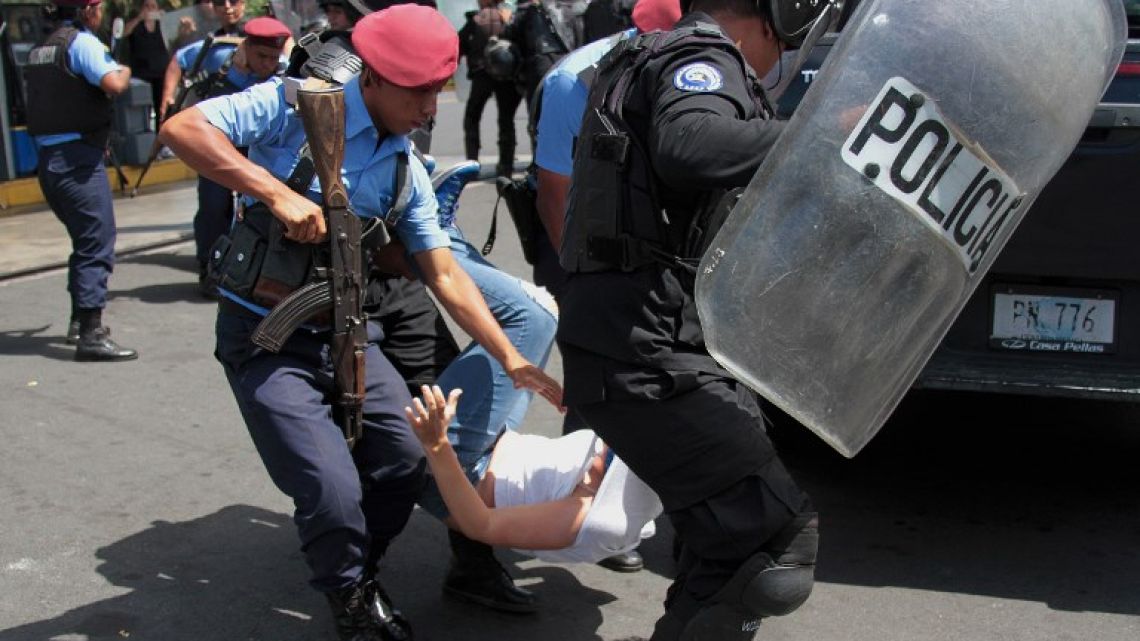 Nicaraguan riot police officers detain a protester during a demonstration led by opposition groups to demand the release of those arrested for taking part in anti-government protests.