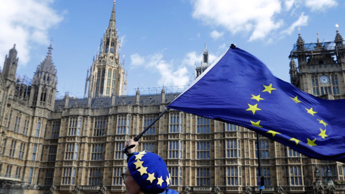 An anti-Brexit campaigner shows her support for Europe waving a European Union flag outside Parliament in London, Monday, March 25, 2019.