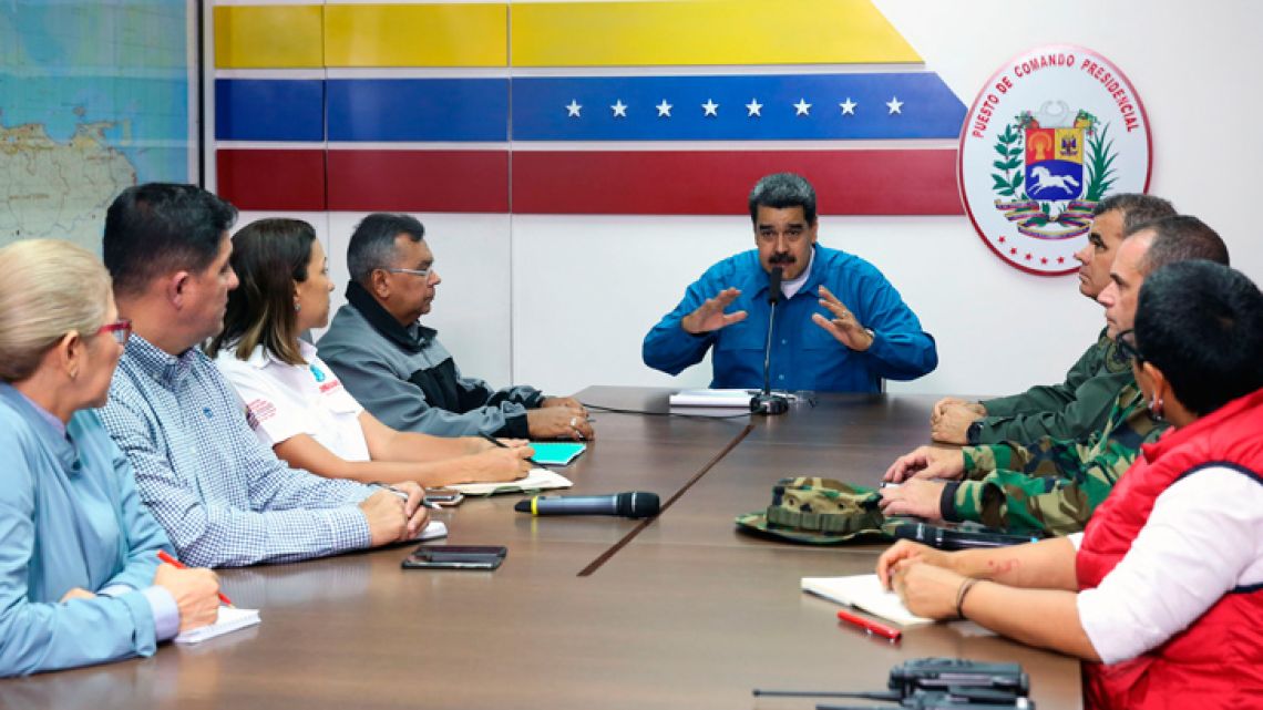 This handout photo released by Venezuelan Presidency shows President Nicolás Maduro and Defence Minister Vladimir Padrino, along with other members of the government, announcing a 30-day electricity rationing plan, at the Miraflores Palace in Caracas, on March 31, 2019. 