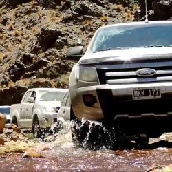 La caravana avanza por el lecho de un río.