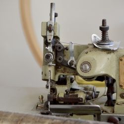 Varias máquinas de coser pequeñas y de época, un solo maniquí en la entrada del taller y un espejo de 3 cuerpos son los objetos destacados del taller.