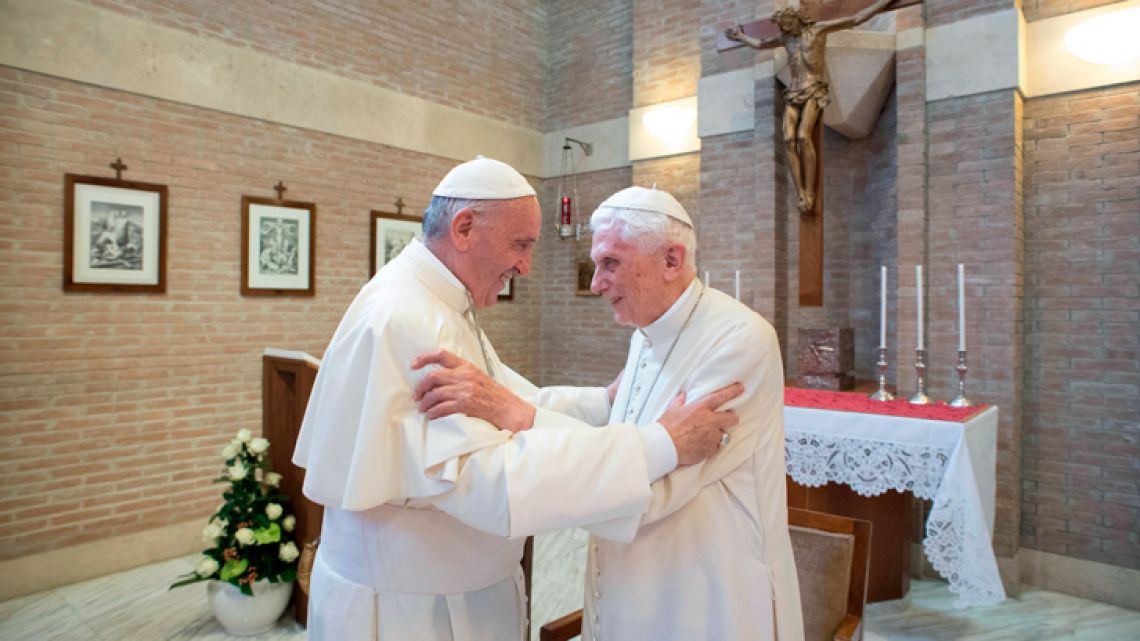 In this file handout picture released on February 15, 2018 by the Vatican press office shows Pope Francis (left) greeting Pope Benedict XVI at the Vatican, on June 28, 2017. 