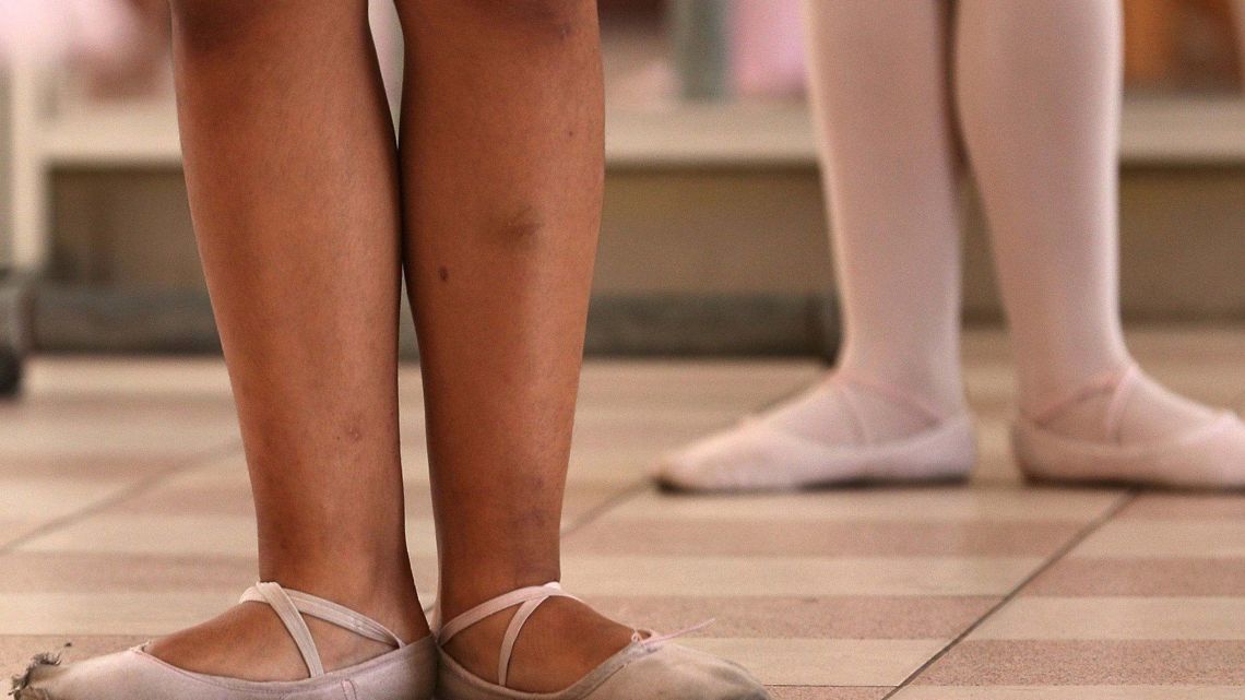 Young ballet students stand in first position in a dance studio at a public school in the Chorrillos neighborhood, a poor part of Lima, Peru.