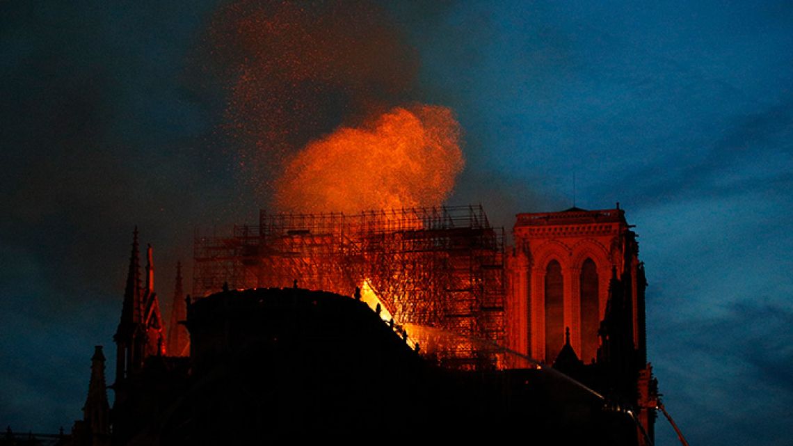 Firefighters use hoses as Notre Dame cathedral burns in Paris, Monday, April 15, 2019. A catastrophic fire engulfed the upper reaches of Paris' soaring Notre Dame Cathedral as it was undergoing renovations Monday, threatening one of the greatest architectural treasures of the Western world as tourists and Parisians looked on aghast from the streets below. 
