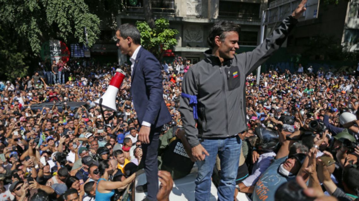 Venezuelan opposition leader and self-proclaimed interm president Juan Guaidó (left) and high-profile opposition politician Leopoldo López greet supporters in Caracas.