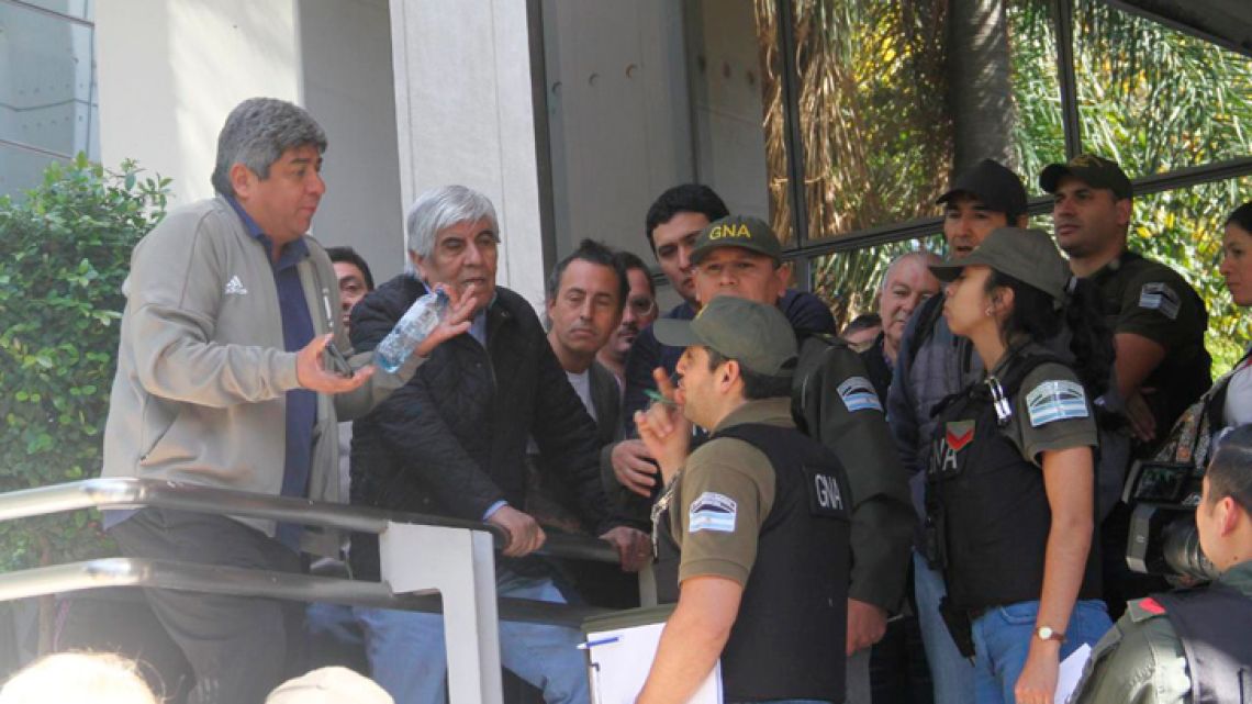 Officials from the Camioneros union (including Hugo Moyano) argue with Gendarmerie officers outside the labour group's headquarters.