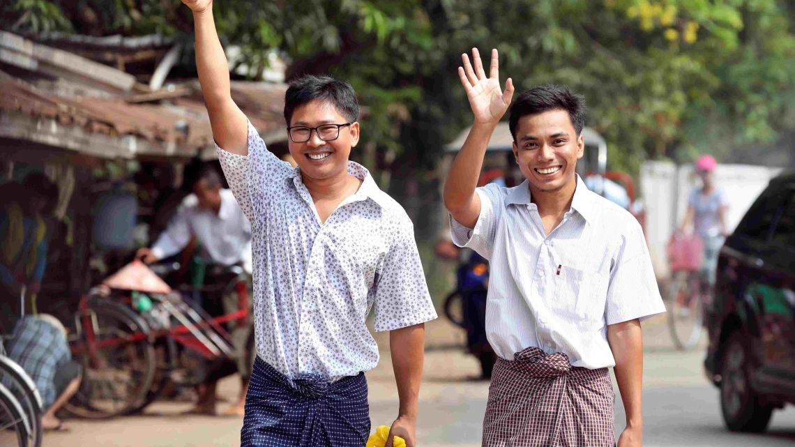 Reuters journalists Wa Lone (L) and Kyaw Soe Oo gesture as they walk to Insein prison gate after being freed in a presidential amnesty in Yangon on May 7, 2019.