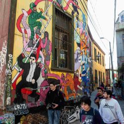 Tourists walk past street murals in Valparaíso, Chile, on April 22, 2019.