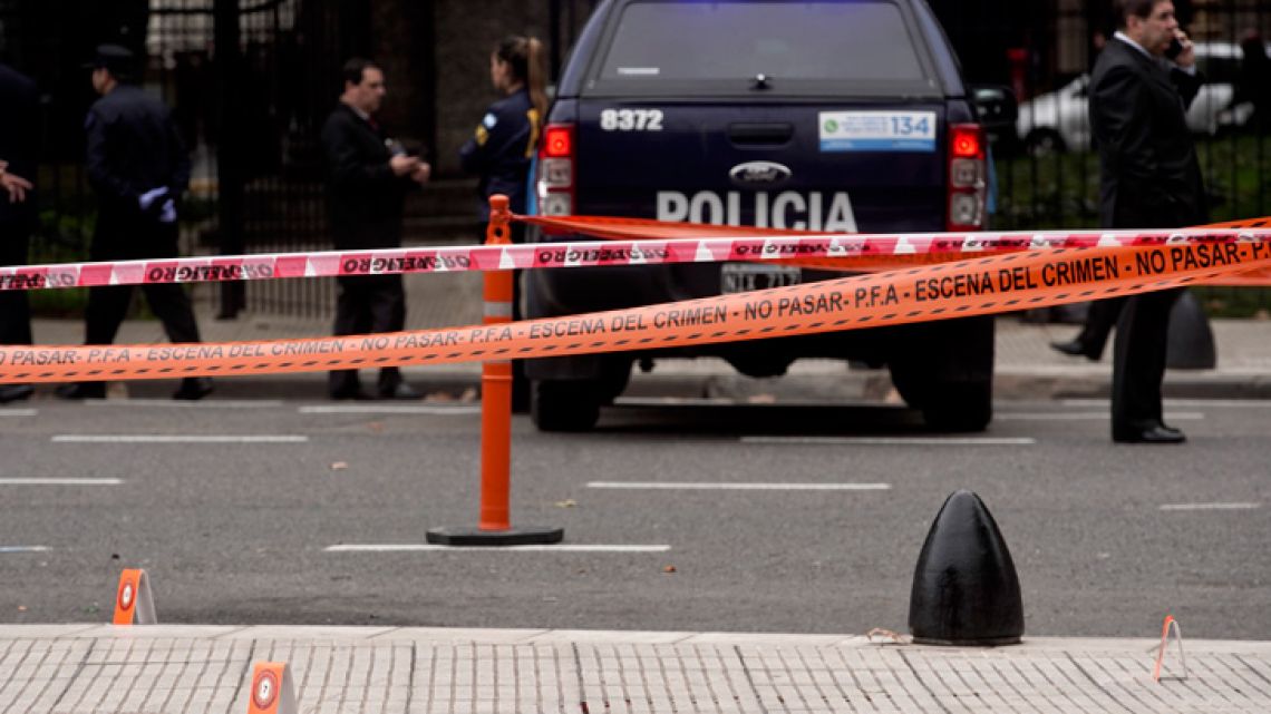 Police stand near the crime scene where lawmaker Héctor Olivares was seriously injured and another man killed after they were shot at from a parked car near the National Congress building, in Buenos Aires, Argentina, Thursday, May 9, 2019. 