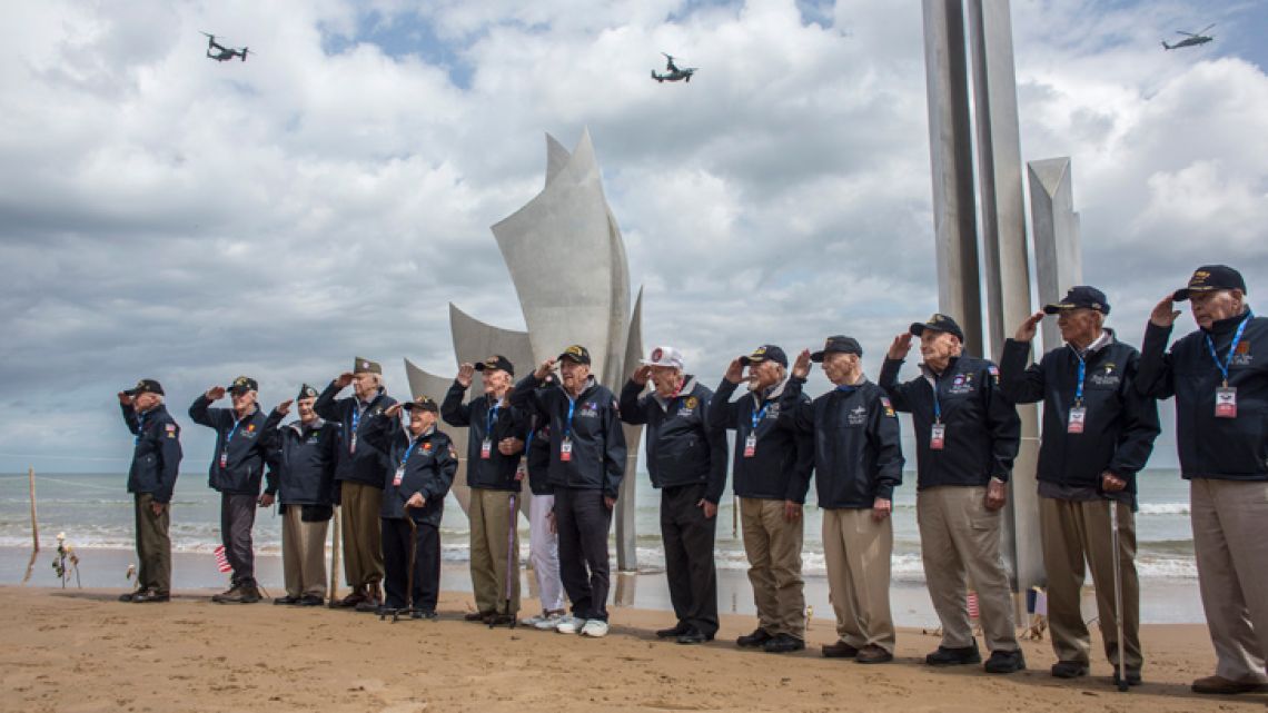 World War II veterans from the United States salute as they pose in front of Les Braves monument at Omaha Beach in Saint-Laurent-sur-Mer, Normandy, France, Monday, June 3, 2019. Europe is preparing to mark the 75th anniversary of the D-Day invasion which took place on June 6, 1944.