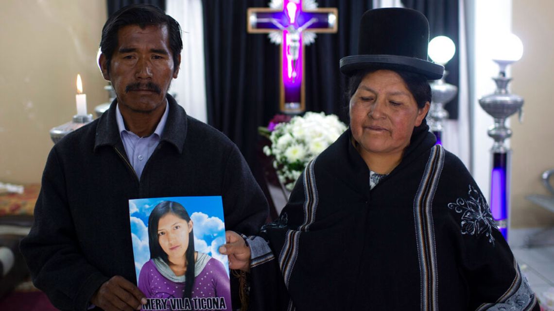 Celso Vila and Luisa Ticona pose with a photo of their late daughter Mery Vila inside the “Stairway to Heaven” funeral home, in La Paz, Bolivia, Thursday, July 11, 2019. Vila’s partner killed the 26-year-old woman by striking her several times on the head with a hammer.