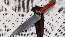 Cuchillo criollo de acero damasco W. Cabo con separadores de micarta y madera de tubérculo de coihue. Vaina de cuero crudo confeccionada por un soguero artesano.