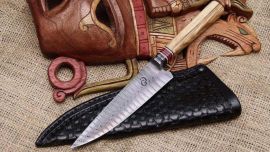 Cuchillo criollo en acero Damasco torsionado y cabo de olivo con separadores de micarta, con vaina sobre cincelada.