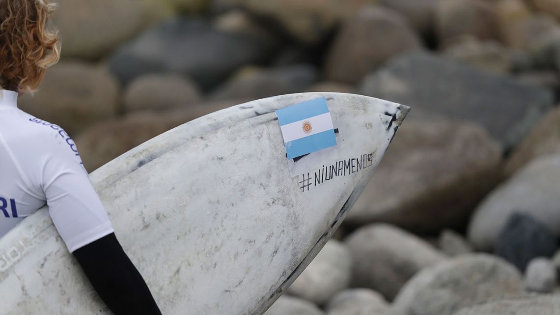 Ornella Pellizzari of Argentina holds her board with a sign that reads in Spanish 