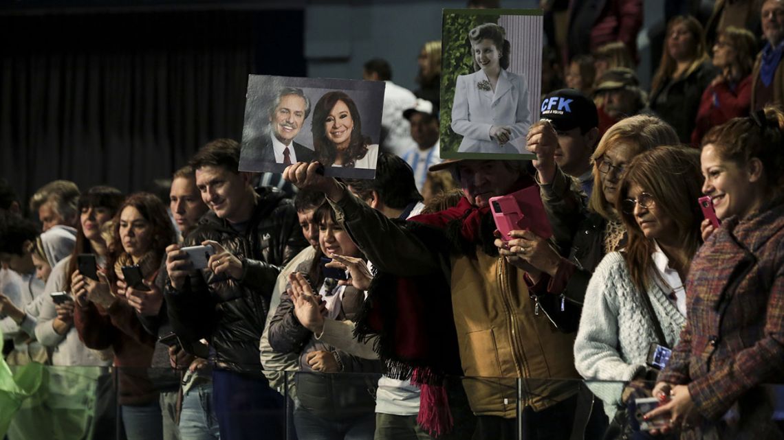 Attendees hold images of Alberto Fernandez, presidential candidate for the Citizen's Unity Party, from left, Cristina Fernandez de Kirchner, Argentina's former president and vice presidential candidate, and former Argentine first lady Eva Perón ahead of a book presentation by Kirchner at DirecTV Arena in Tortuguitas, Argentina, on Saturday, Aug. 3, 2019. 