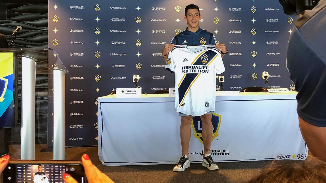 Cristian Pavón holds up his new LA Galaxy jersey as he is introduced to the media at Dignity Health Sports Park in Carson, California.