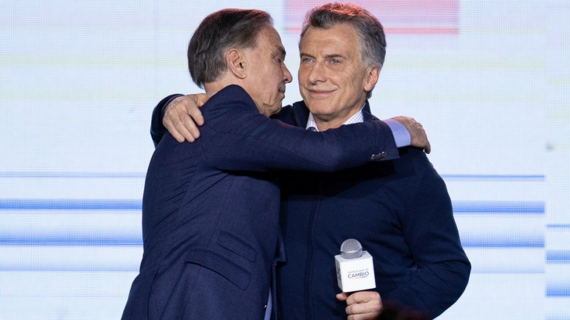 President Mauricio Macri, right, embraces his running-mate Miguel Angel Pichetto at their party's headquarters after primary elections in Buenos Aires, Argentina. 