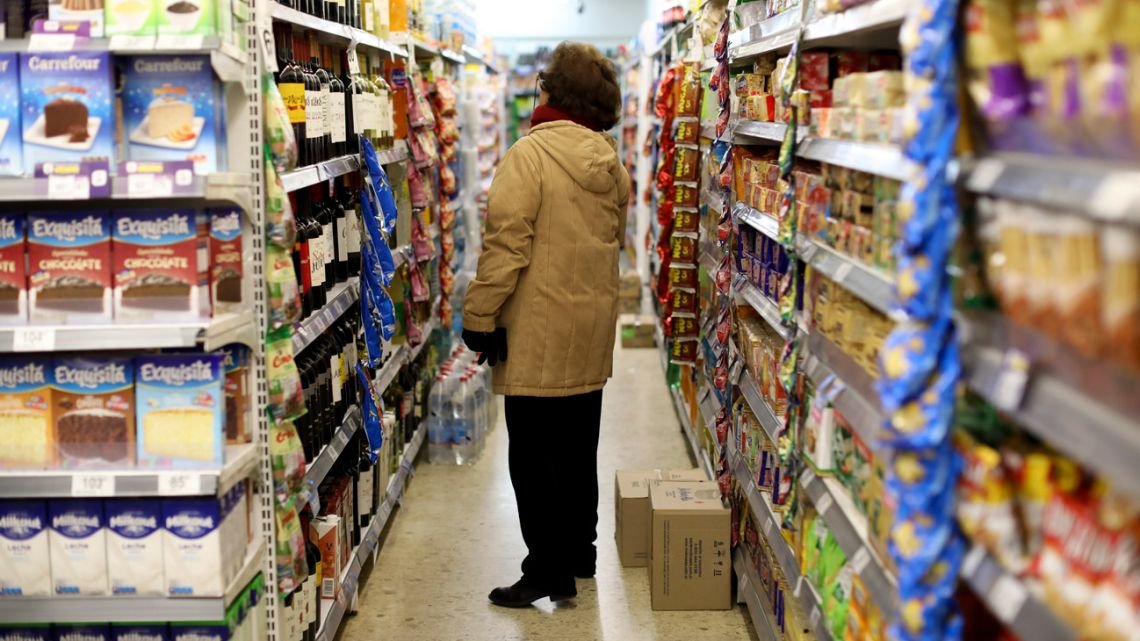 A woman checks prices at a supermarket in Buenos Aires.